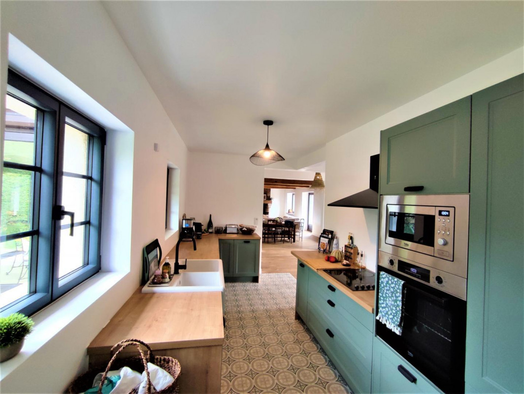 Open Norman kitchen with sage cabinetry and island