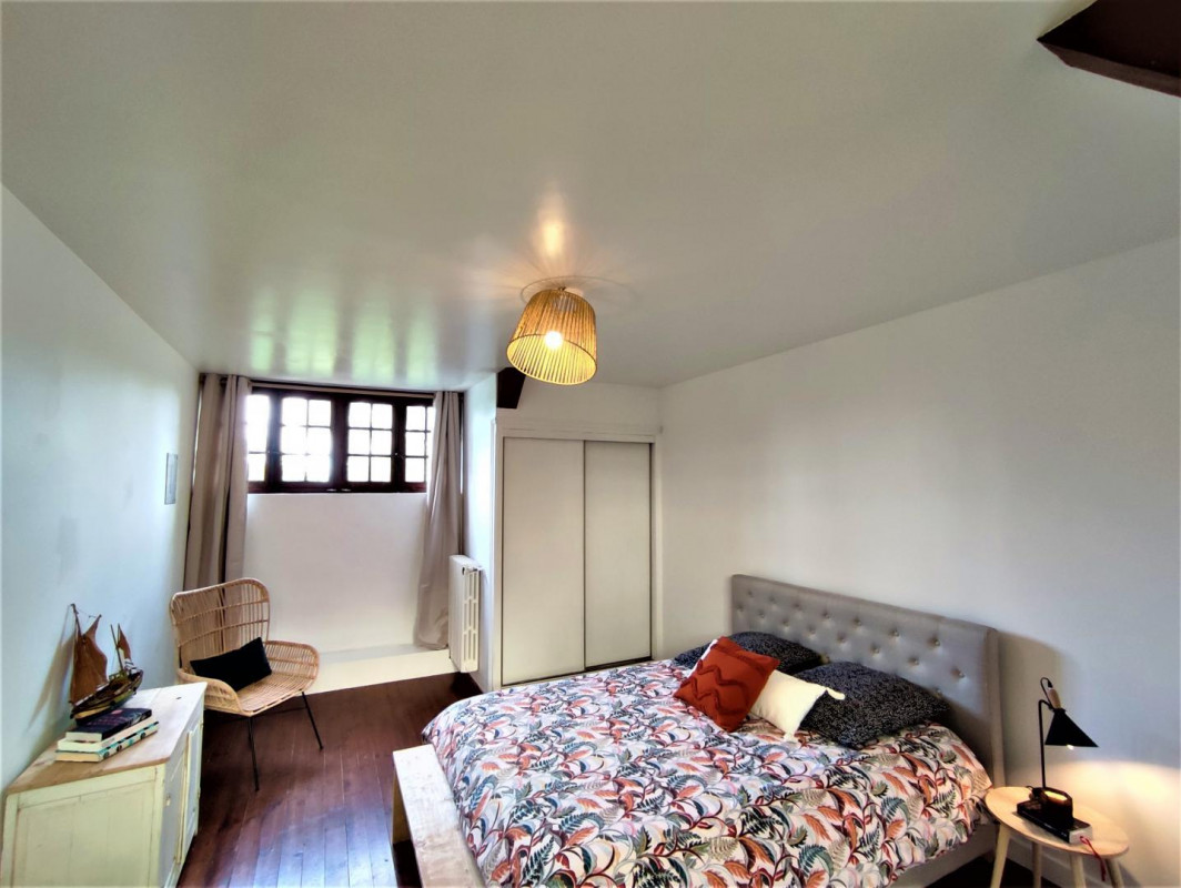 Upstairs primary bedroom with queen bed and beam ceiling