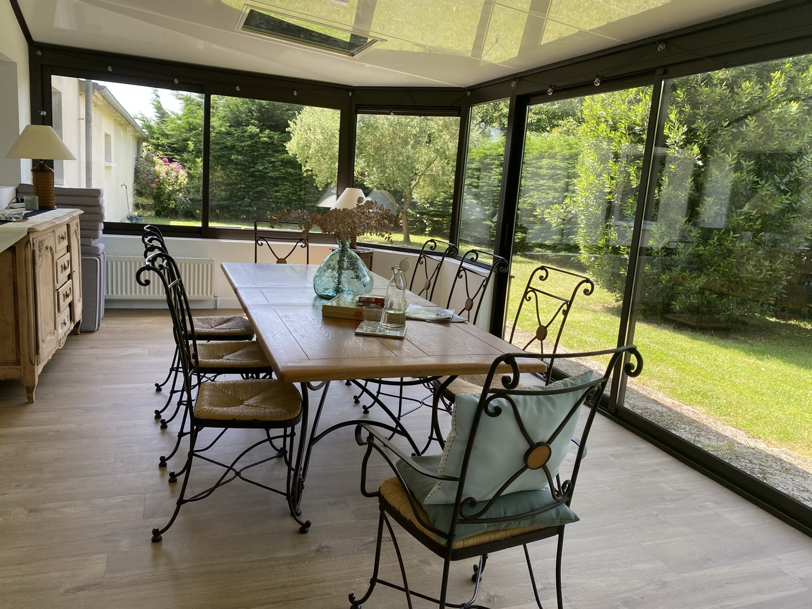 Sun-lit veranda with wrought-iron chairs and the garden beyond