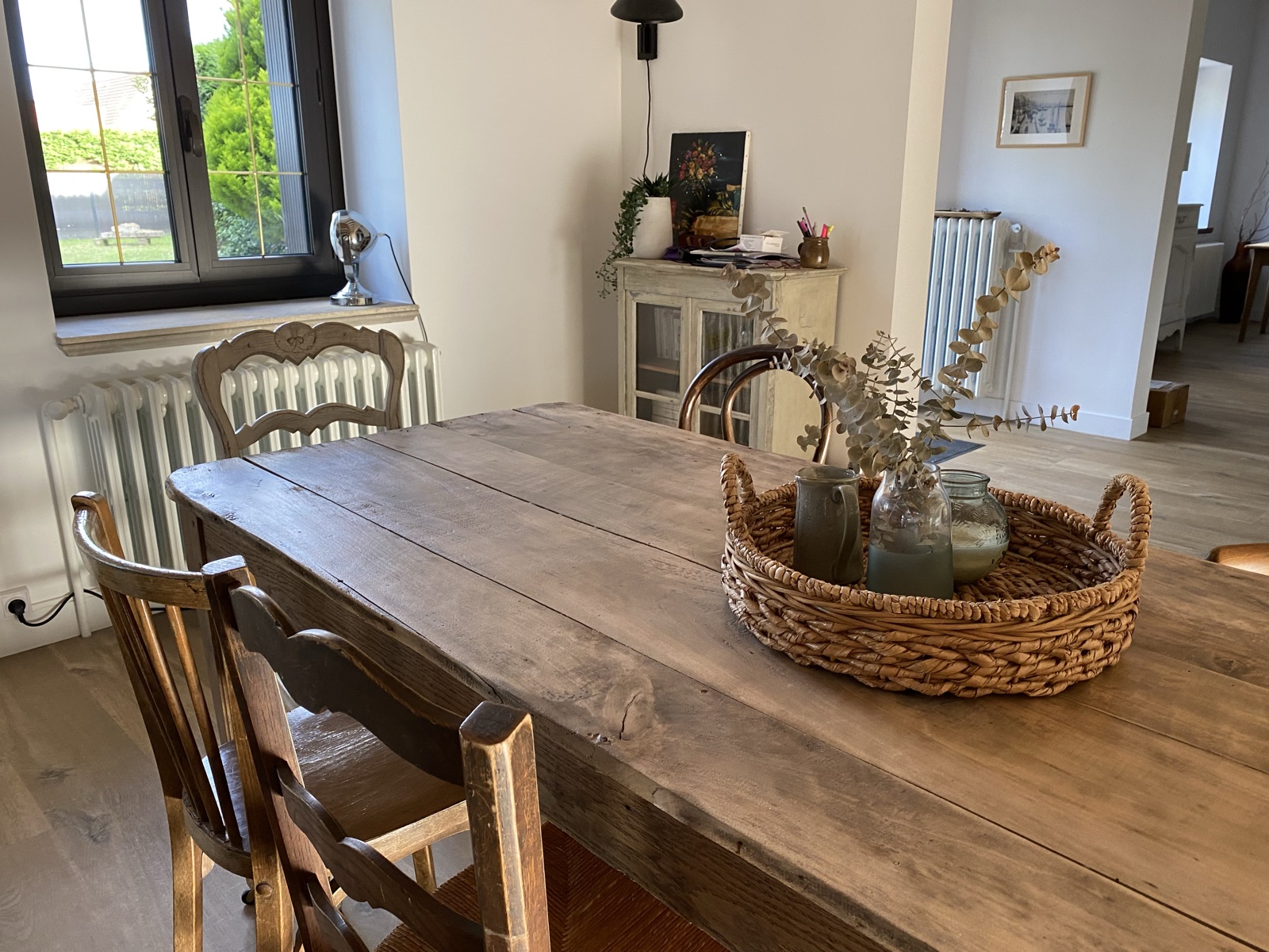 Farmhouse table with woven tray and basket centrepiece, garden window beyond